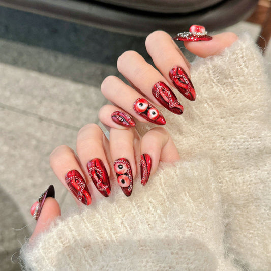 Bold almond-shaped press-on nails featuring captivating eye motifs, traditional paisley art and premium crystal accents