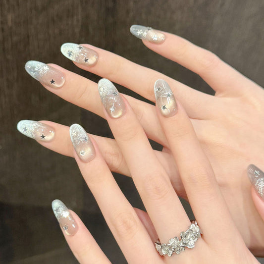 Enchanting oval-shaped short nails featuring starry night theme with shimmering silver base & scattered star details