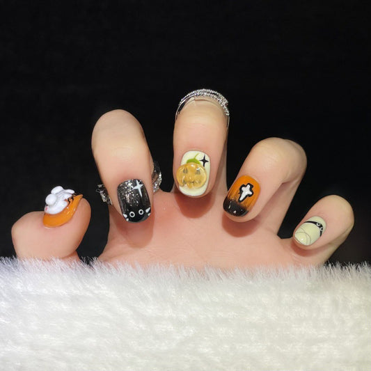 Handcrafted Halloween nails featuring cute ghosts, black cats, and orange-black design - easy DIY application for spooky style