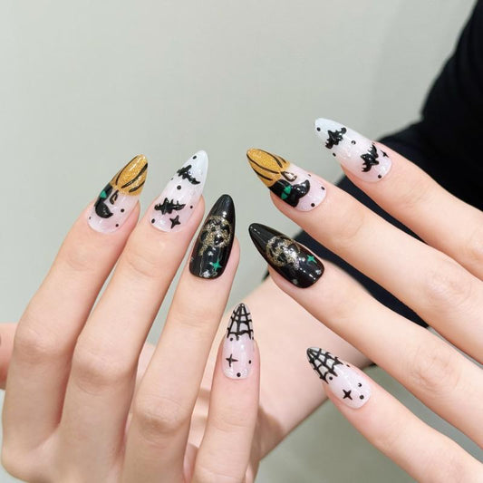 Handcrafted Halloween nails featuring intricate golden skulls, flying bats, crystal embellishments - classic almond shape collection