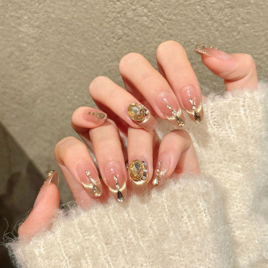 Luxurious almond nails with crystal chain, gold shimmer, champagne gems & rhinestones - perfect for luxury crystal chain gold shimmer elegance