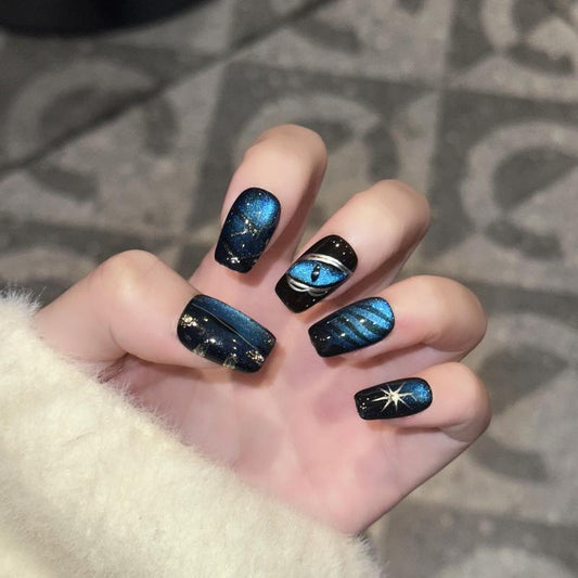 Mystical Halloween galaxy witch coffin short press-on nails with cosmic blue patterns, sparkling stars, and celestial designs