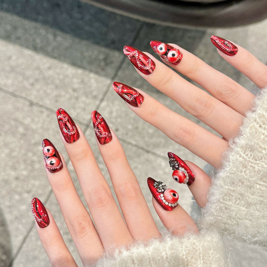 Premium handmade almond press-on nails with mystical red eye designs, intricate paisley patterns and sparkling crystals.