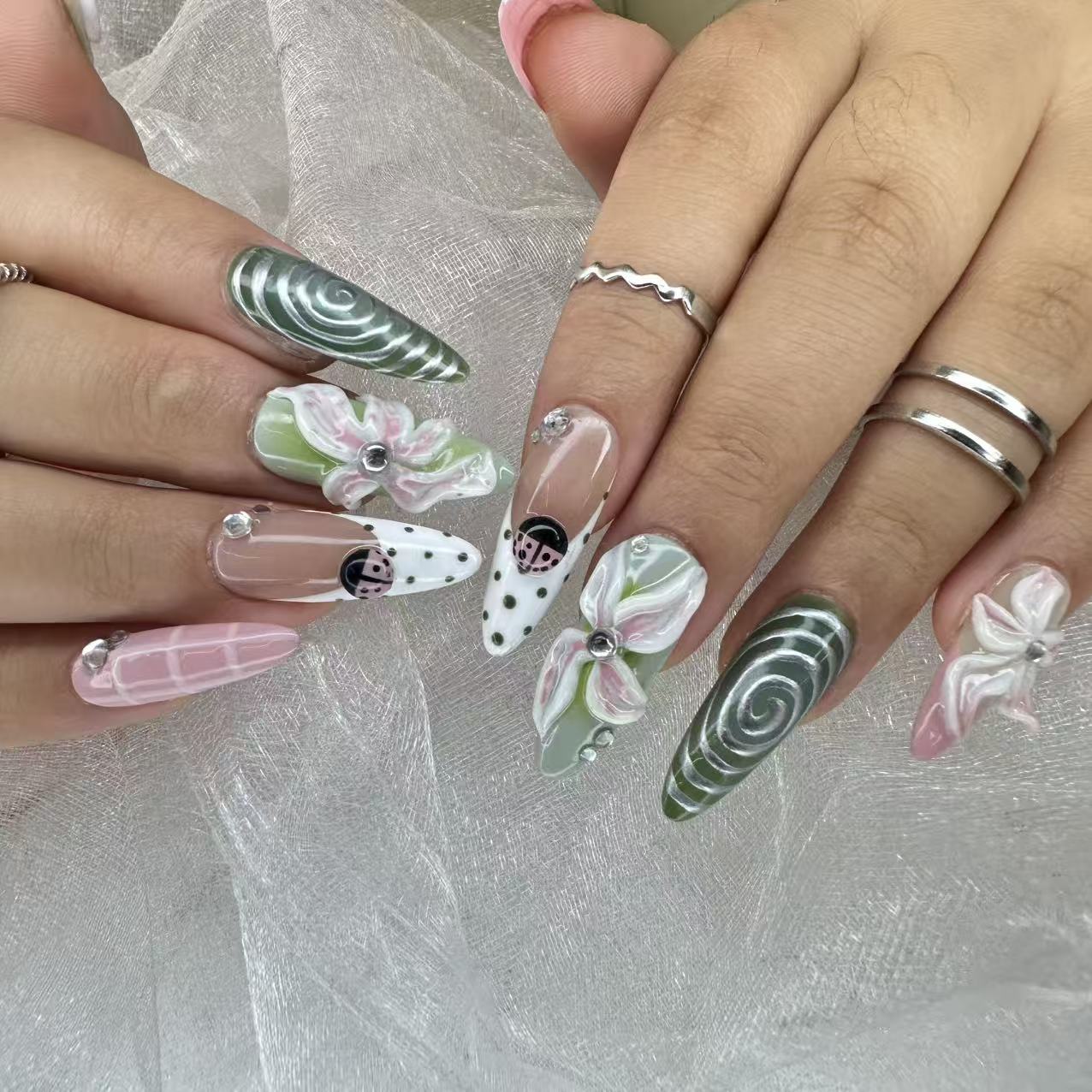 Matcha Garden long almond press-on nails with green polish and 3D floral details