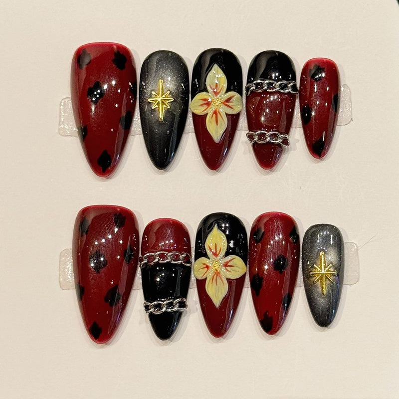 Dark romantic almond press-ons with burgundy-black tortoiseshell, metallic gold stars & silver chains - luxurious gothic nail art"