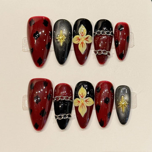 Dark romantic almond press-ons with burgundy-black tortoiseshell, metallic gold stars & silver chains - luxurious gothic nail art"