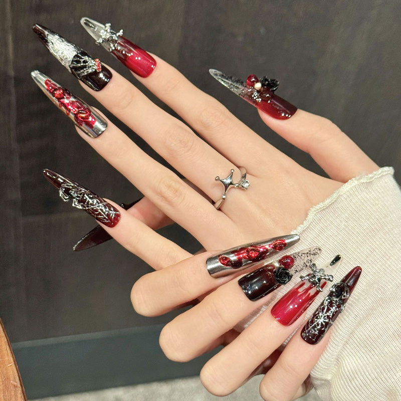Dramatic stiletto long nails with 3D black rose, skull charm, silver shimmer & burgundy-red - perfect for gothic rose skull silver bold elegance