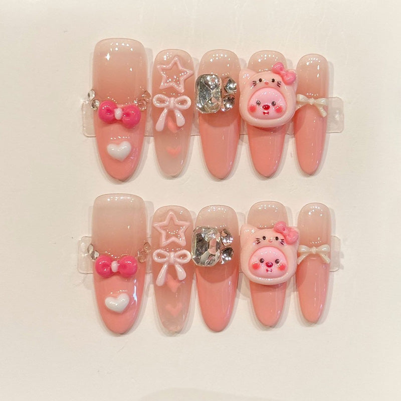 Easy-apply oval false nails in gradient pink with cute 3D charms, metallic details & rhinestone sparkle for instant glamorous look