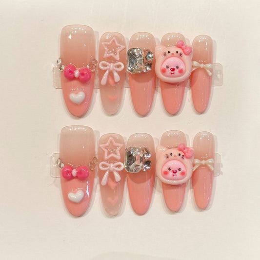 Easy-apply oval false nails in gradient pink with cute 3D charms, metallic details & rhinestone sparkle for instant glamorous look