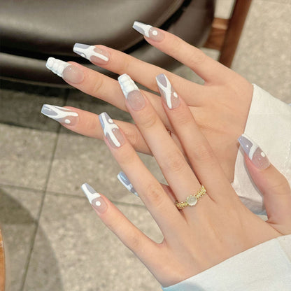 Edgy coffin-shaped press-on nails featuring detailed anatomical bone motifs and minimalist nude background. Perfect for gothic style