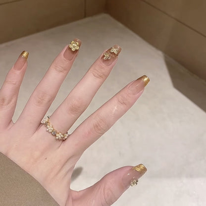 Elegant coffin medium press-on nails with gold French tips & 3D clover charms - perfect for lucky charm style & sophisticated celebrations