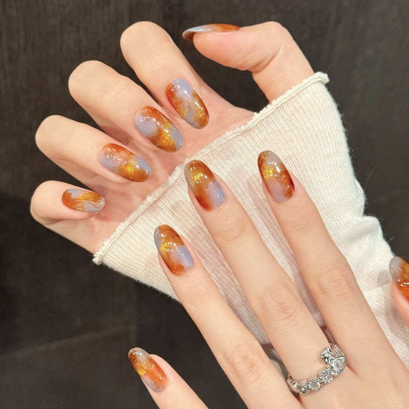 Elegant oval nails with luxurious tortoiseshell pattern, gold glitter & amber gradient - perfect for timeless sophistication & refined style