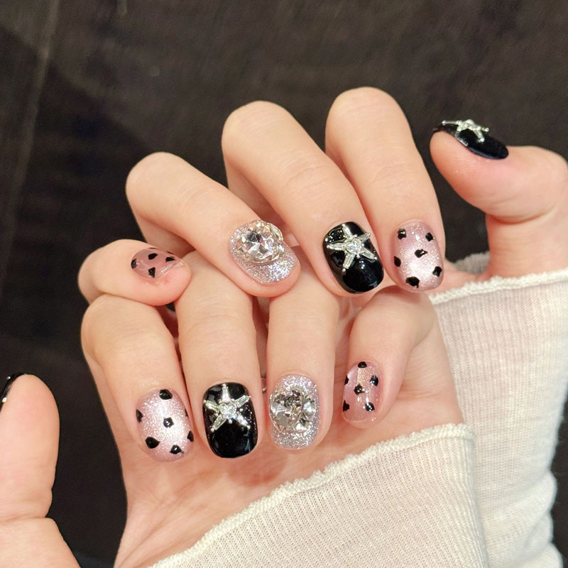 Elegant squoval short press-on nails with silver starfish, pink gems, black hearts & glitter - perfect for starry night elegance & celestial style