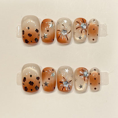 Fierce yet practical short squoval press-ons with leopard print, metallic stars & rhinestone flower - handcrafted caramel nail art