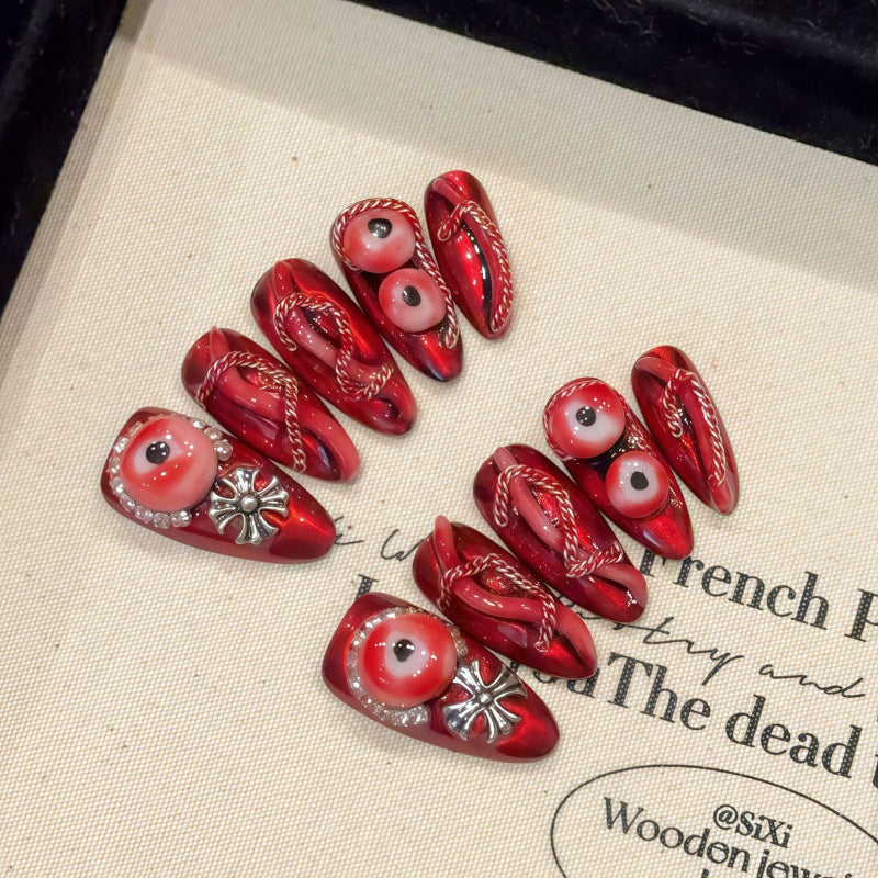 Handcrafted almond nails with striking red eye designs and ornamental patterns. Perfect for gothic and alternative styles
