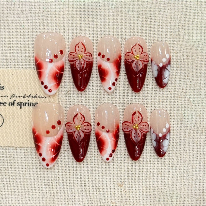 KAPOWNAILS almond nails featuring floral design - delicate burgundy flower, rich gradient, gold details, pearl dots, handcrafted quality, 10-piece elegant set