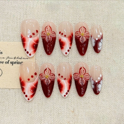 KAPOWNAILS almond nails featuring floral design - delicate burgundy flower, rich gradient, gold details, pearl dots, handcrafted quality, 10-piece elegant set