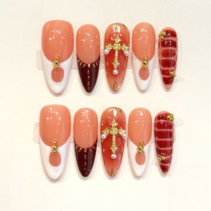 KAPOWNAILS almond nails featuring opulent design - rich burgundy, gold rhinestone cross, pearl accents, stripe pattern, handcrafted quality, 10-piece set