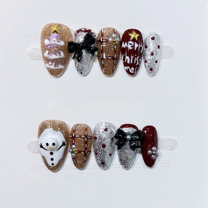 KAPOWNAILS almond nails featuring playful Christmas design - snowman charm, gingerbread, gold sparkle, Merry Christmas text, 10-piece set
