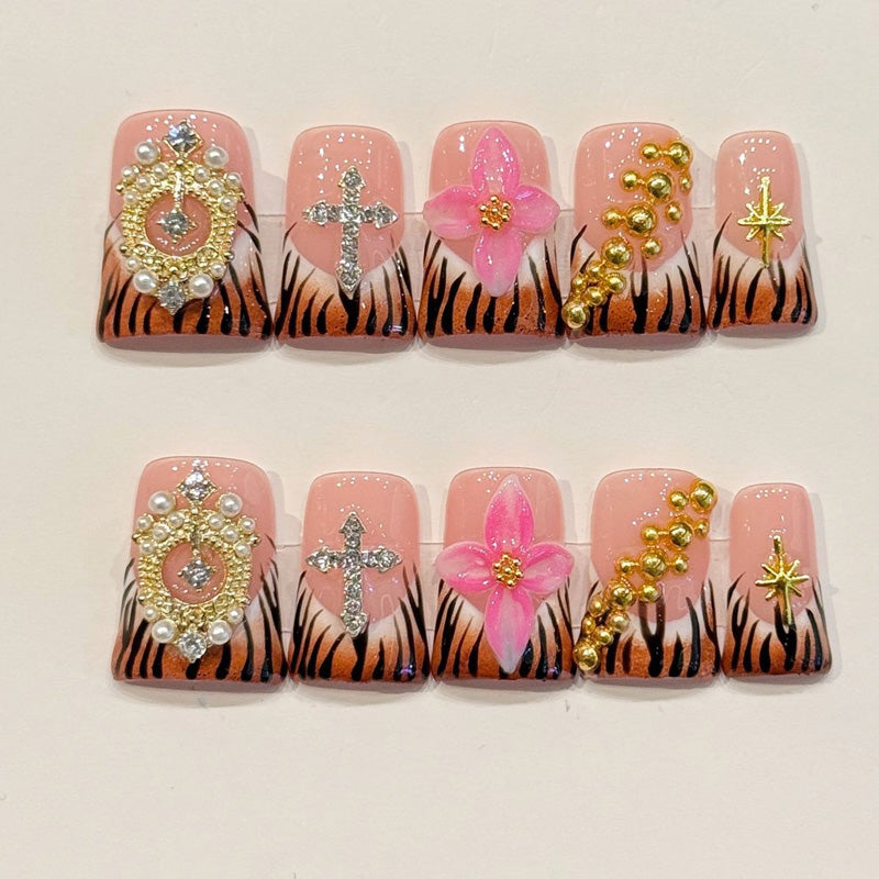 KAPOWNAILS duck nails featuring bold design - tiger stripes, delicate pink flower, rhinestone cross, gold crown, star accents, handcrafted quality, 10-piece set