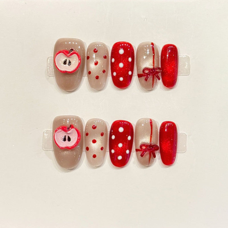 KAPOWNAILS oval nails featuring sweet Christmas design - adorable apple, vibrant red bow, playful polka dots, handcrafted quality, 10-piece festive set