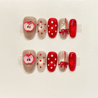 KAPOWNAILS oval nails featuring sweet Christmas design - adorable apple, vibrant red bow, playful polka dots, handcrafted quality, 10-piece festive set