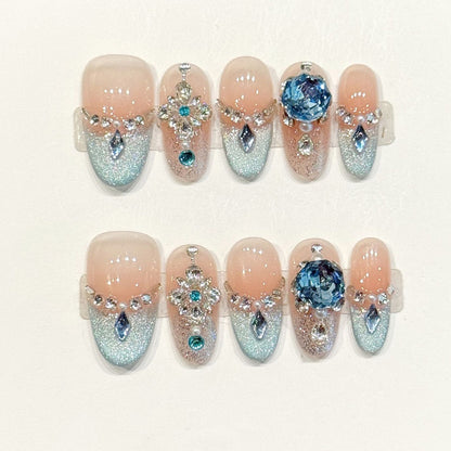 Luxurious almond press-ons with aqua glitter gradient, rhinestone chain jewelry & blue geode art - handcrafted ocean opulence