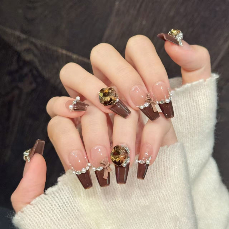 Luxurious coffin nails with crystal embellishments, pearl accents, brown French tips & bow - perfect for luxury crystal pearl French elegance