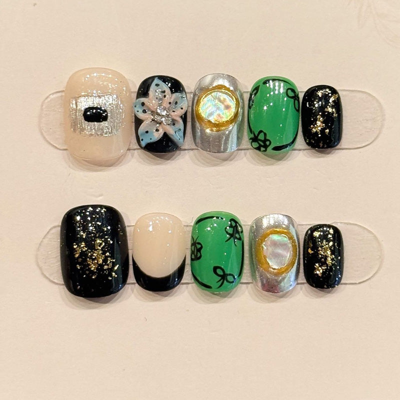 Playful short squoval press-ons with hand-painted clovers, emerald green, iridescent chrome & gold glitter - lucky charm nail art