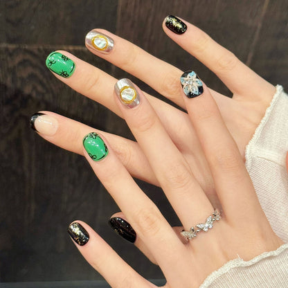 Practical short squoval nails with clover designs, jewel-toned emerald, dimensional florals & metallic accents - charming collection