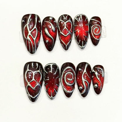 Premium almond nails for dramatic style - red glitter hearts, bold flame patterns, silver metallic outlines, sparkling rhinestones, perfect for romantic celebrations