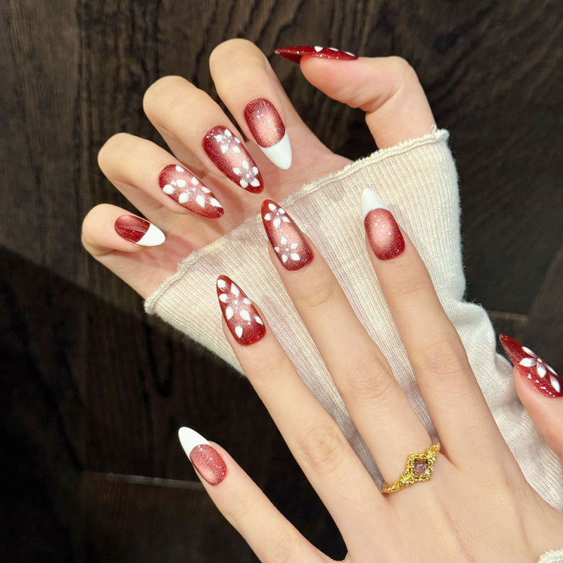 Premium almond nails for romantic elegance - red shimmer ombre, 3D white flowers, gold accents, soft French tips, perfect for spring celebrations