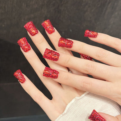 Premium duck nails for glamorous impact - vibrant red finish, large crystal embellishments, gold glitter, elegant bows, dazzling rhinestones, perfect for luxury celebrations