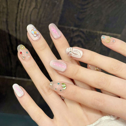 Premium oval nails for dreamy charm - iridescent pink shimmer, delicate butterfly, colorful rhinestones, gold circle accents, perfect for romantic celebrations