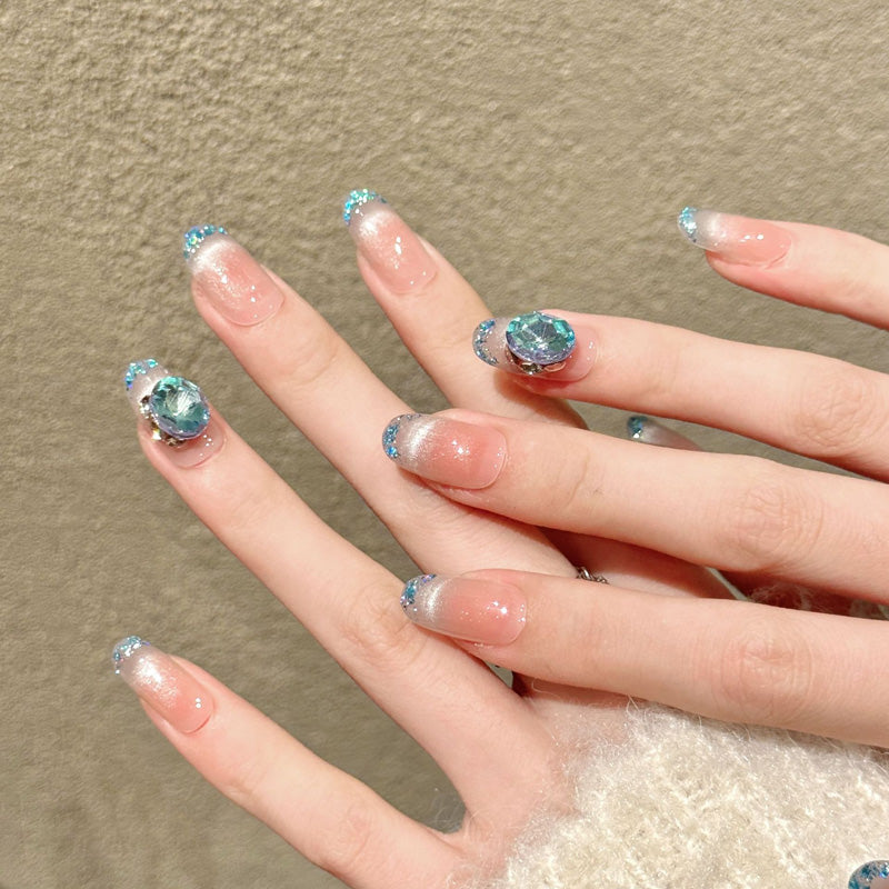 Premium oval nails for ocean elegance - large blue crystal, silver-blue glitter French tips, peach gradient, iridescent shells, perfect for beach celebrations