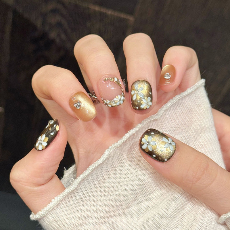 Premium squoval short nails for elegant charm - 3D white flowers, gold glitter, sparkling crystals, brown-pink gradient, perfect for sophisticated celebrations