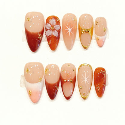 Radiant handmade almond nails with coral gradient, 3D cherry blossom & gold stars - Spring elegance 