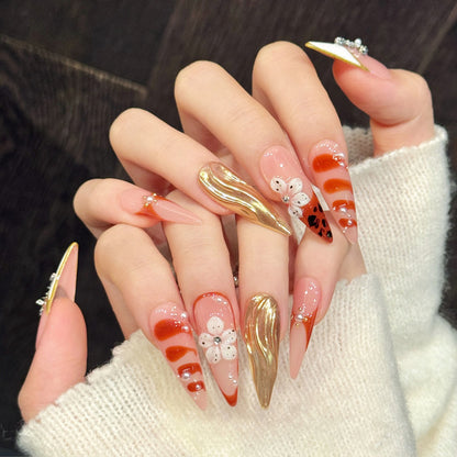 Red-carpet ready stiletto false nails with rhinestone pendants, metallic gold & floral details - bold 10-piece glamorous nail set