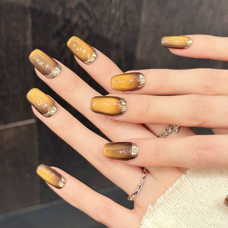 Rich amber coffin nails with frosted sugar-crystal texture, gradient depth & gleaming gold accents - indulgent luxury collection