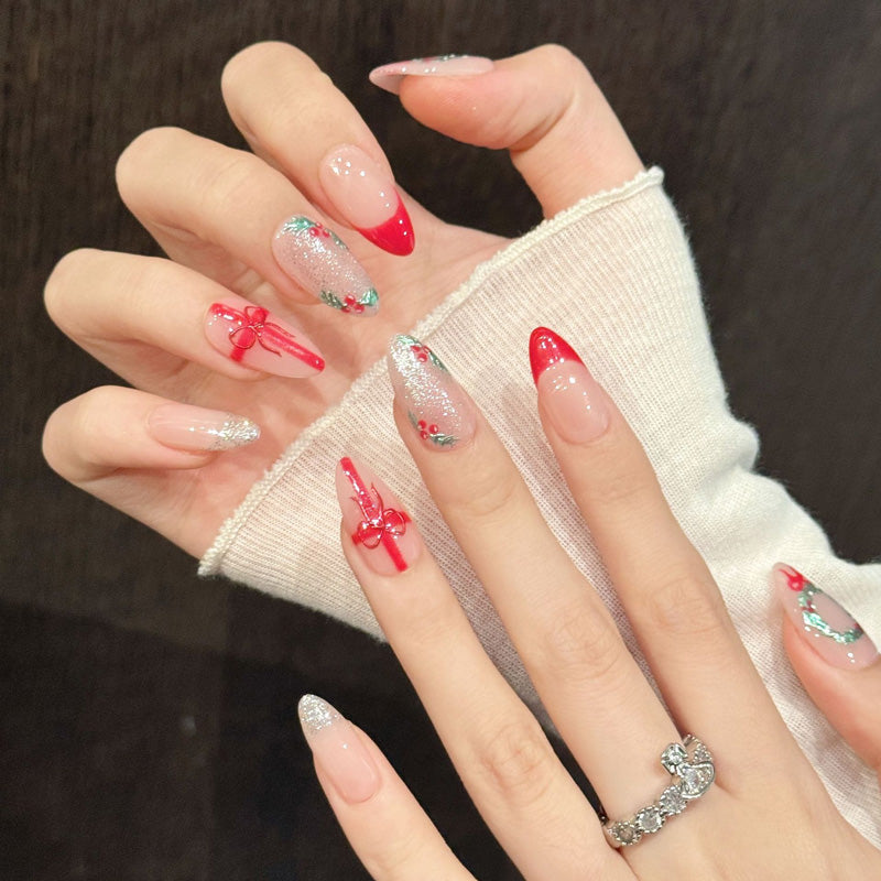 Seasonal almond nails with miniature holiday wreaths, glossy red bows & gradient glitter - celebrate Christmas in style