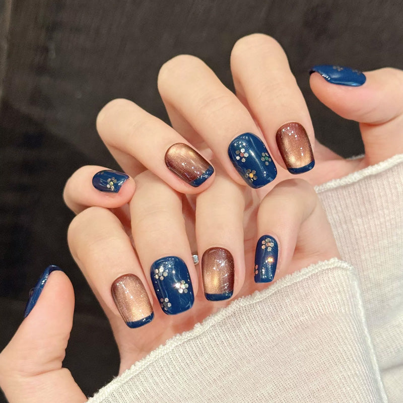 Sophisticated navy squoval false nails featuring delicate floral art, warm metallic shimmer & crystal accents - 10-piece short set