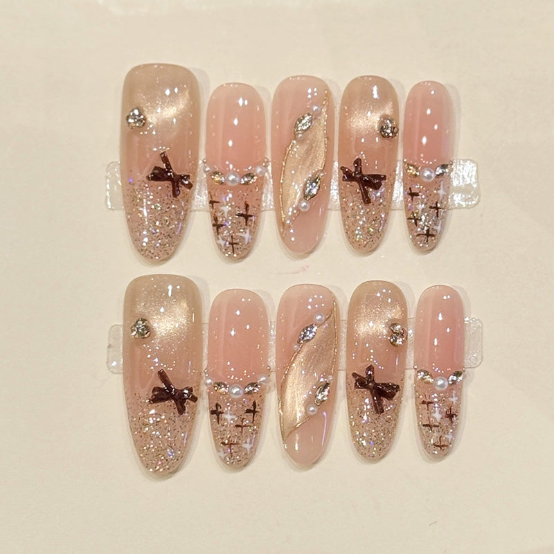 Sophisticated oval press-ons with bronze bow charms, pearl accents & champagne glitter - handcrafted bridal-ready elegant nails