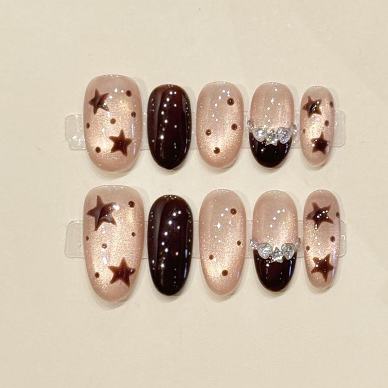 Starry night oval press-ons with bronze star appliqués, crystal bow & iridescent shimmer - handcrafted celestial nail art collection