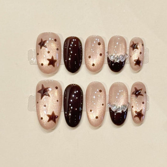 Starry night oval press-ons with bronze star appliqués, crystal bow & iridescent shimmer - handcrafted celestial nail art collection