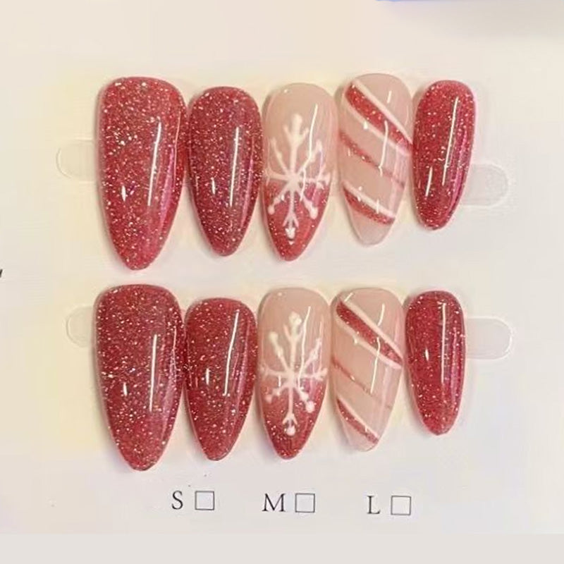 Stunning almond press-on nails with red glitter, white snowflakes, candy cane stripes & silver accents - perfect for sparkling Christmas snowflake glamour