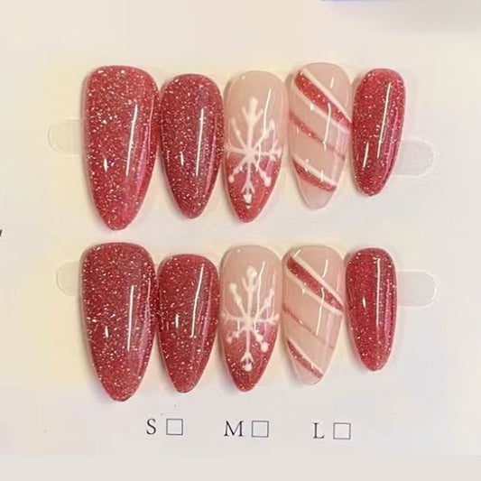 Stunning almond press-on nails with red glitter, white snowflakes, candy cane stripes & silver accents - perfect for sparkling Christmas snowflake glamour
