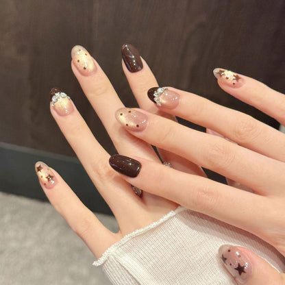 Whimsical chocolate & champagne oval false nails featuring dimensional stars, rhinestone bow & twilight dots - dreamy 10-piece set