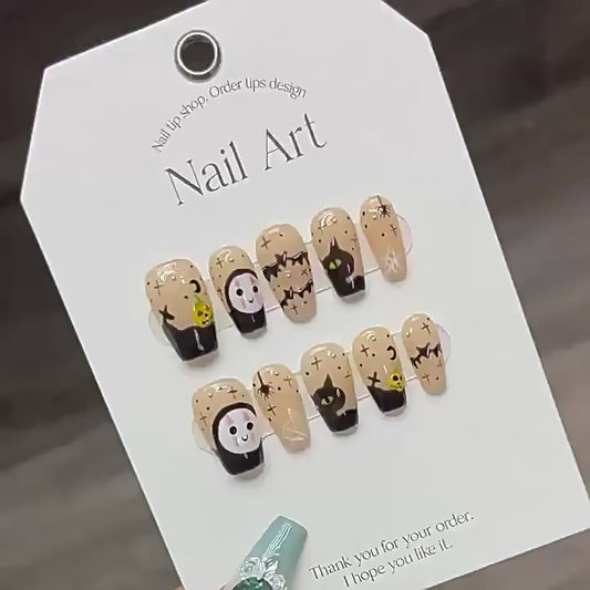 Handcrafted Halloween nails featuring kawaii ghost characters, black cats with green eyes - coffin medium shape for sweet spooky style